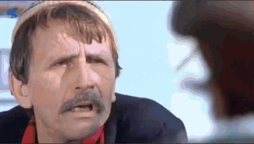 a close up of a man with a mustache making a face