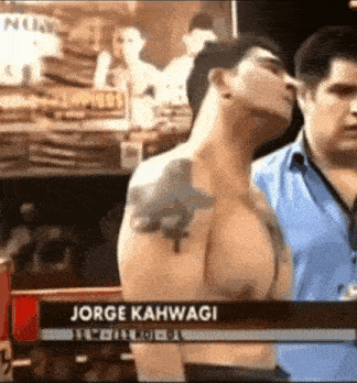 a shirtless man with a tattoo on his arm is being interviewed by jorge kahwagi .