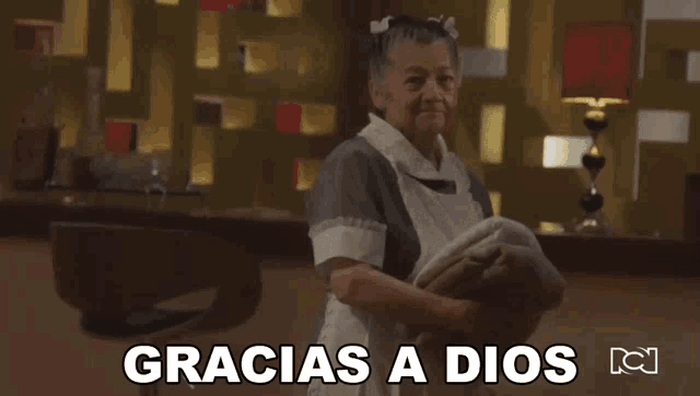 a maid holding a blanket with the words gracias a dios on the bottom
