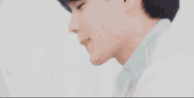 a close up of a person 's face with their finger on their mouth .