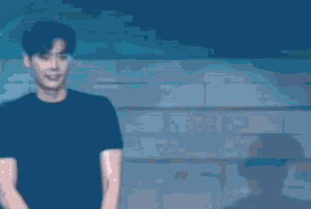a blurry picture of a man in a black shirt with a blue light behind him