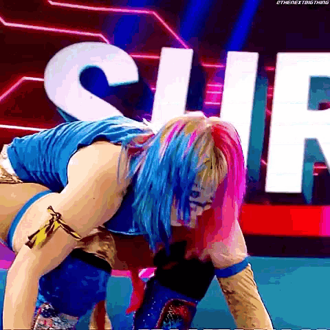 a woman with blue and pink hair is kneeling down in front of a sign that says s.i.r.