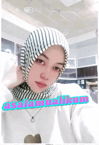 a woman wearing a striped scarf and a sweater with the words selamatikum written on it