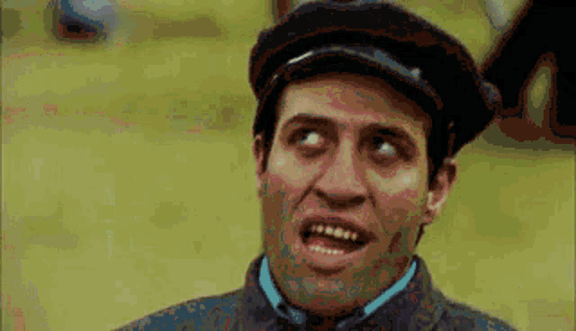 a man wearing a hat is making a funny face and making a funny face .
