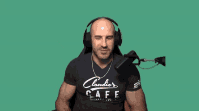 a man wearing headphones and a claudio 's cafe shirt