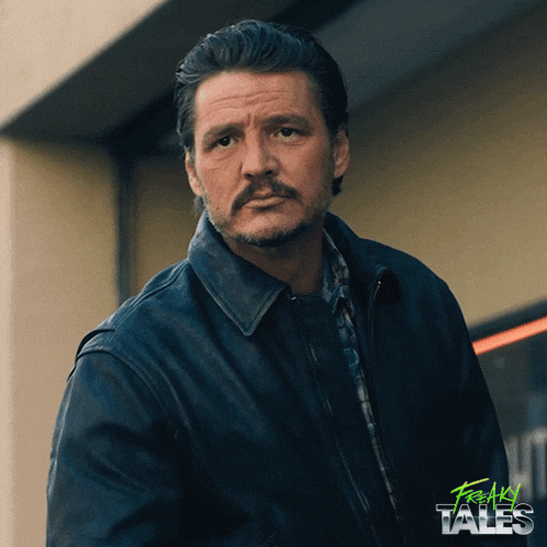 a man with a mustache is standing in front of a building with freaky tales written on the bottom