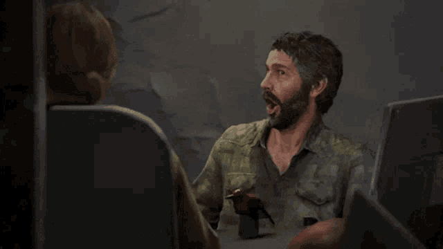 a man with a beard is talking to a woman in a dark room