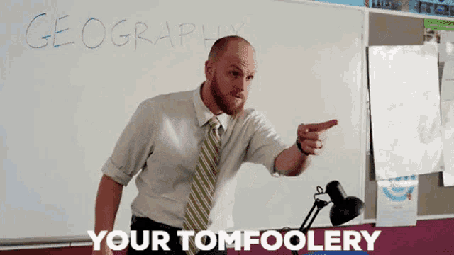 a man in front of a white board that says geography