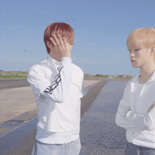 two young men standing next to each other one with red hair and the other with blonde hair