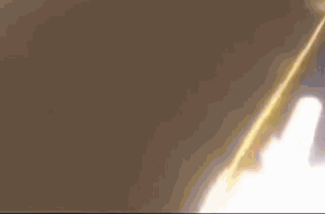 a close up of a person 's face with a yellow flame coming out of it 's mouth .