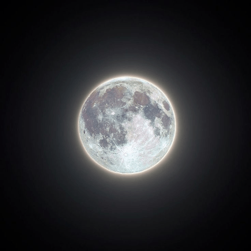 a full moon in a dark sky with a glowing edge