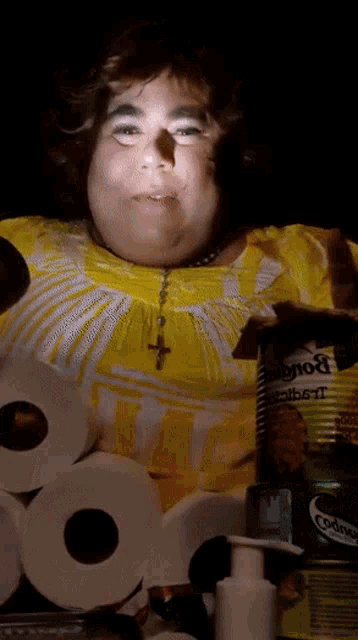 a woman in a yellow shirt is surrounded by toilet paper rolls