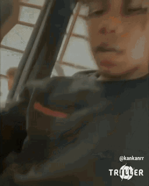 a young man with dreadlocks is sitting in a car talking to a man .