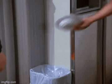 a person is throwing a plate in a trash can