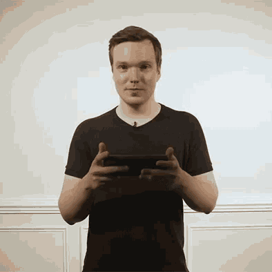 a man in a black shirt is holding a cell phone