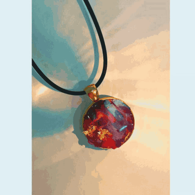 a necklace with a turquoise pendant on a white cord