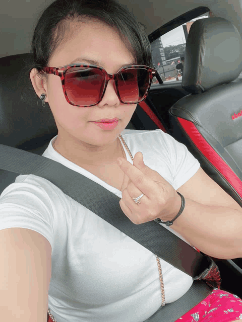 a woman wearing sunglasses is sitting in a car