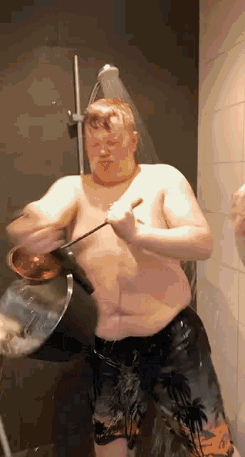 a shirtless man is taking a shower while holding a pot
