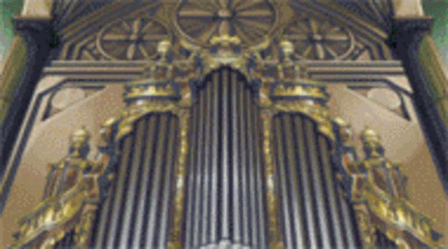 a close up of a church organ with gold decoration