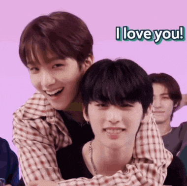 two young men are hugging each other with the words i love you behind them .