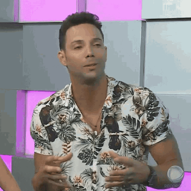 a man wearing a floral shirt with a watch on his wrist