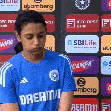 a girl wearing a blue shirt that says dream11