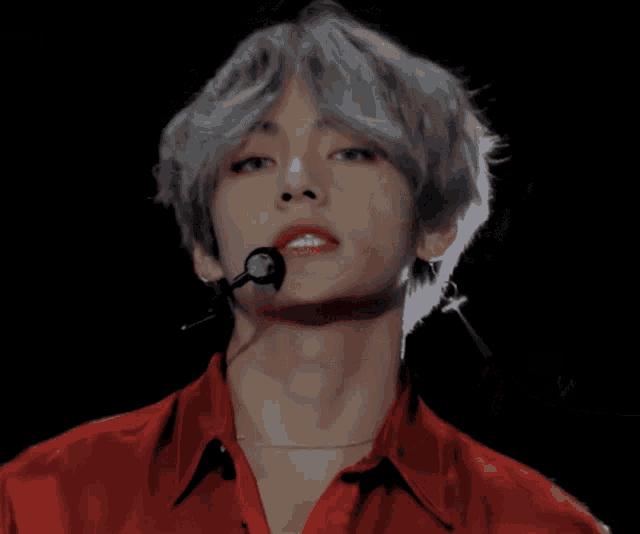 a man with gray hair is wearing a red shirt