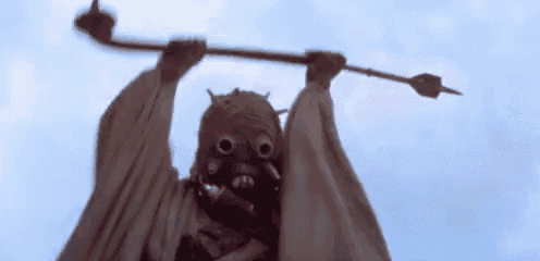 a close up of a person wearing a mask holding a stick in the air .