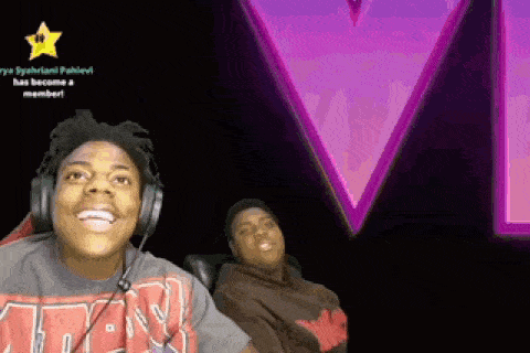 a man wearing headphones is smiling in front of a neon sign that says star