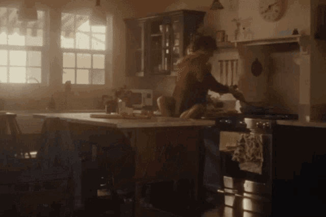 a man and a child are cooking in a kitchen with a clock in the background