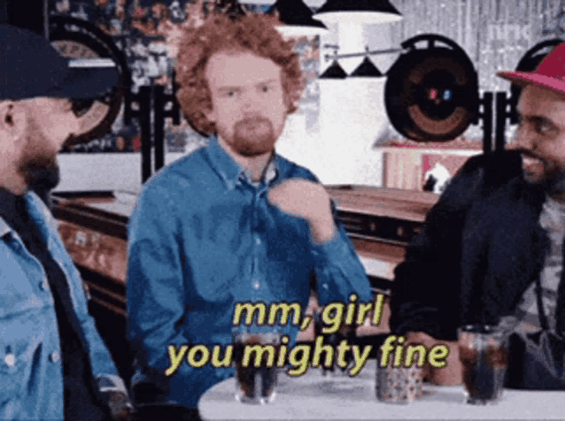 a group of men are sitting around a table and one of them is saying mm girl you mighty fine
