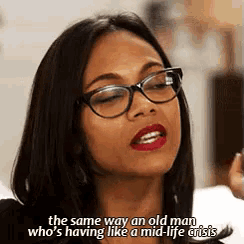 a woman wearing glasses and red lipstick is saying the same way an old man who 's having like a mid-life crisis