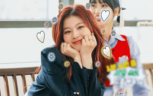 a woman with red hair is smiling with hearts and flowers around her