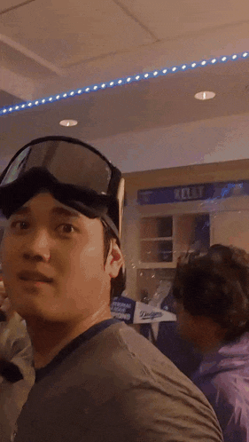 a man wearing a helmet and goggles is standing in front of a sign that says belt