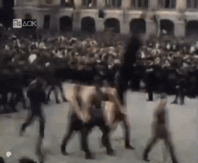 a blurry picture of a crowd of people walking in front of a building with the letters aok on the bottom