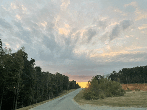 a road with a water tower in the distance