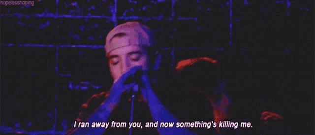 a man singing into a microphone with the words i ran away from you and now something 's killing me written below him