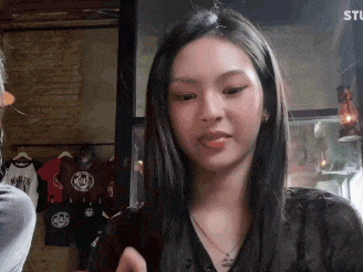 a woman with long hair is sitting in a room with a man .
