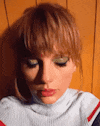 a close up of a woman 's face wearing a turtleneck sweater and earrings .