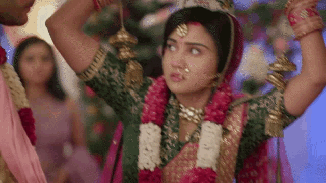 a bride and groom are holding hands and the bride has a nose ring on