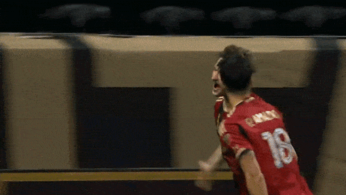 a soccer player wearing a red shirt with the number 18 on it