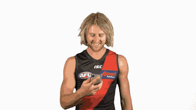 a man wearing an afl jersey looking at his phone