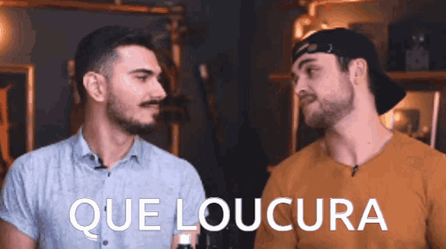 two men are standing next to each other with the words que loucura written on the bottom