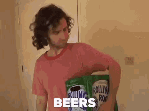 a man with curly hair is holding a stack of beer cans in his hands .