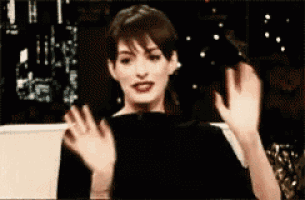 a woman in a black shirt is waving her hands