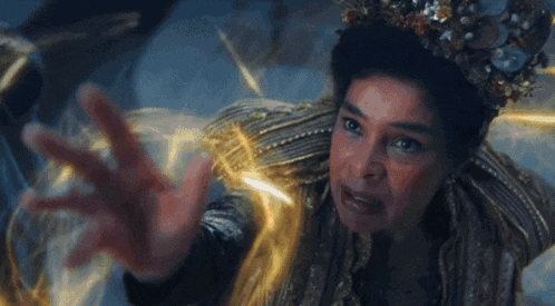 a woman with a crown on her head reaches out her hand