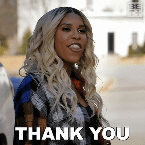 a woman in a plaid shirt is smiling and says thank you