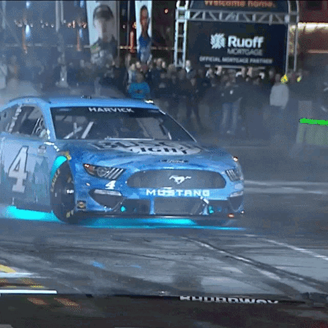 a blue mustang race car with the number 4 on it