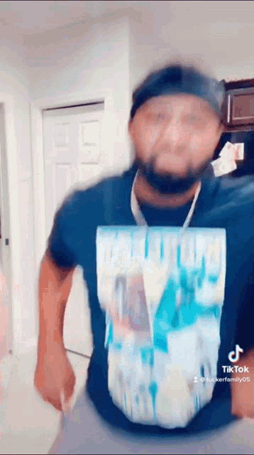 a man wearing a black shirt with a blue graphic on it is dancing .