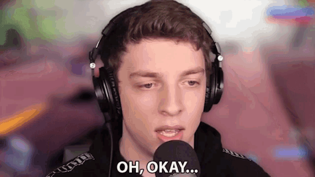 a man wearing headphones is talking into a microphone and saying oh okay
